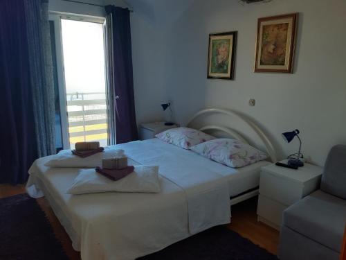 a bedroom with a bed and a chair and a window at Apartments by the sea Gradac, Makarska - 15642 in Gradac