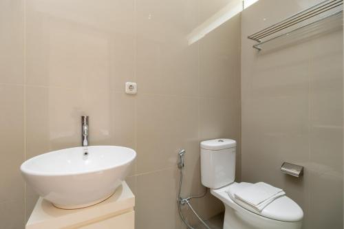 a white bathroom with a sink and a toilet at RedDoorz near Transmart Kalimalang in Jakarta