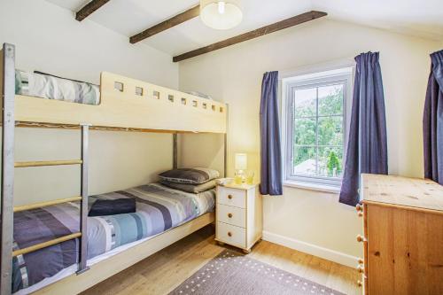 a bedroom with two bunk beds and a window at Penlan in Beddgelert