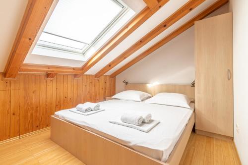 a bedroom with a large bed with a skylight at Family friendly apartments with a swimming pool Sutivan, Brac - 15665 in Sutivan
