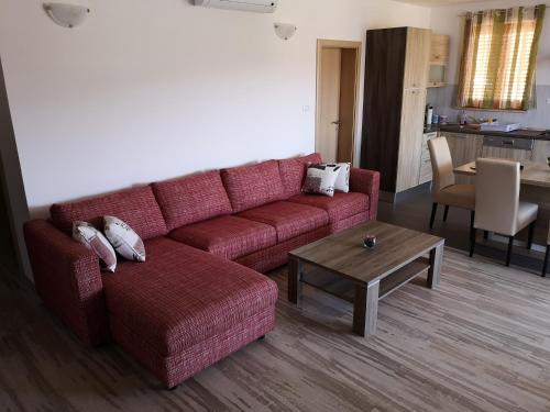 un soggiorno con divano rosso e tavolo di Apartments with a parking space Cres - 15672 a Cres