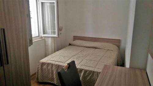 a small bedroom with a bed and a window at Apartments by the sea Korcula - 15689 in Korčula