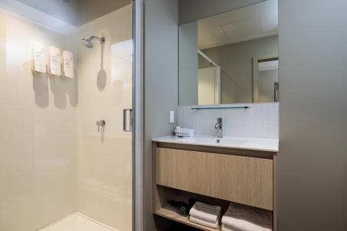 a bathroom with a sink and a shower at Quest 256 Lambton in Wellington