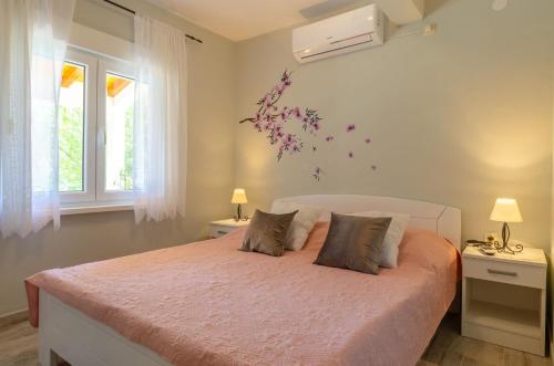 a bedroom with a bed with flowers on the wall at Apartments by the sea Karbuni, Korcula - 15699 in Prizba