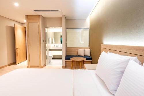 a hotel room with a bed and a chair at Hotel Foret The Spa in Busan