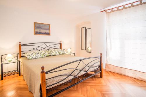 a bedroom with a bed and a large window at Apartments by the sea Vrbnik, Krk - 15754 in Vrbnik
