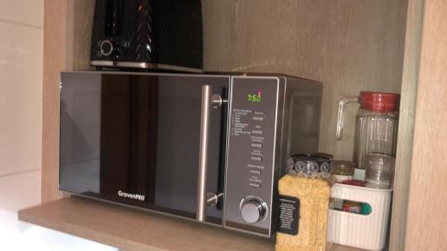 a microwave on a shelf in a kitchen at Departamento residencial Valle Nevado in Lo Barnechea
