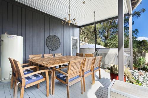 a wooden dining table and chairs on a patio at Hygge House - Calm & Cosy Escape in Nature in Nungurner