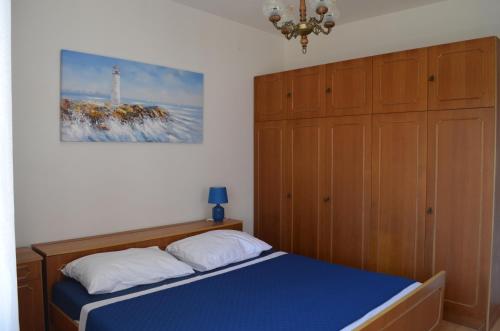 a bedroom with a bed and a painting on the wall at Seaside holiday house Sutomiscica, Ugljan - 15965 in Preko