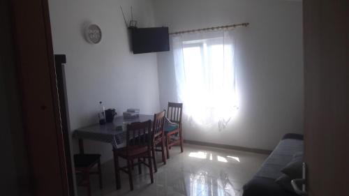 a living room with a table and chairs and a window at Apartments with WiFi Podstrana, Split - 15970 in Podstrana