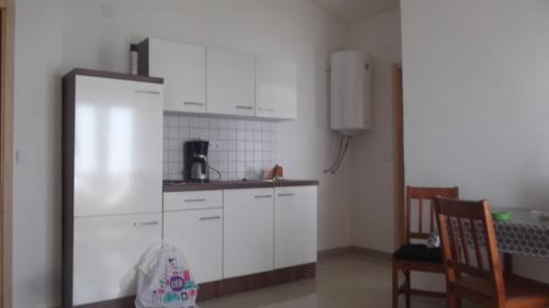 a kitchen with white cabinets and a refrigerator at Apartments with WiFi Podstrana, Split - 15970 in Podstrana