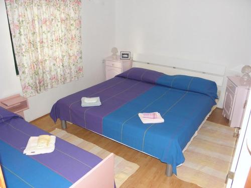 a bedroom with a bed with blue sheets and a table at Apartments by the sea Crnja Luka, Korcula - 15978 in Blato