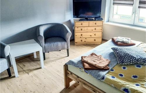 a small room with a bed and a chair and a tv at Gorgeous Home In Postomino With Wifi in Postomino