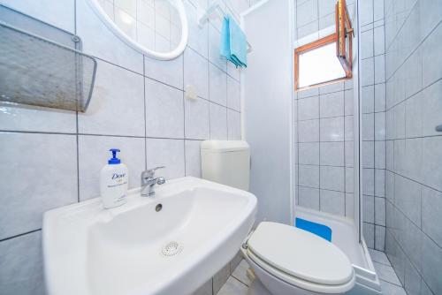 a white bathroom with a sink and a toilet at Apartments by the sea Sobra, Mljet - 15993 in Babino Polje