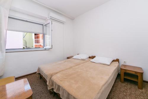 um quarto com uma cama grande e uma janela em Rooms by the sea Gradac, Makarska - 16006 em Gradac