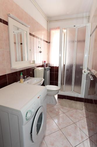 a bathroom with a toilet sink and a washing machine at Apartments with parking space Pag - 16016 in Pag