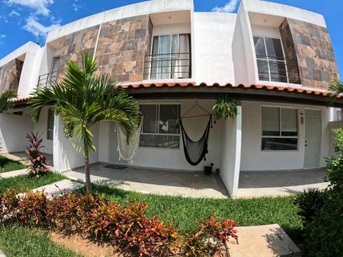 a house with a hammock in front of it at Villa familiar en Playa del Carmen con alberca in Playa del Carmen