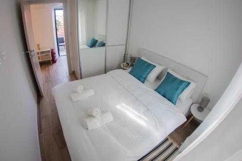Un dormitorio con una cama blanca con almohadas azules. en Studio Gradac 16039a, en Gradac