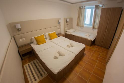 a bedroom with a bed with yellow pillows and a tub at Apartments by the sea Gradac, Makarska - 16039 in Gradac