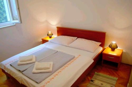 a bedroom with a bed with two towels on it at Holiday house with a parking space Zaostrog, Makarska - 16043 in Zaostrog