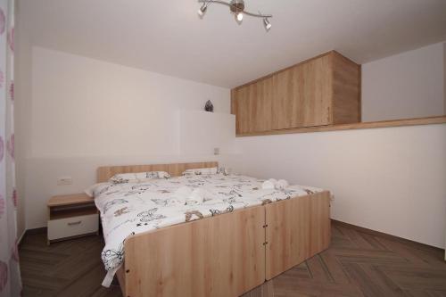 een slaapkamer met een groot bed met een houten frame bij Apartments with a parking space Zrnovo, Korcula - 16045 in Korčula
