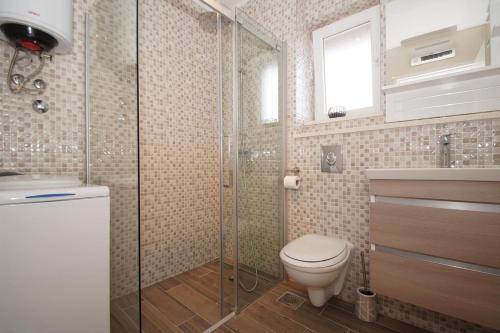 een badkamer met een toilet en een glazen douche bij Apartments with a parking space Zrnovo, Korcula - 16045 in Korčula