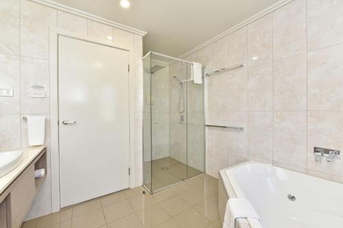 uma casa de banho com um chuveiro, uma banheira e um lavatório. em Ironbark Hill Villa 1 Tyrian em Pokolbin