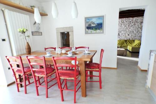 a dining room with a wooden table and red chairs at Holiday house with a parking space Skrbcici, Krk - 16084 in Vrh