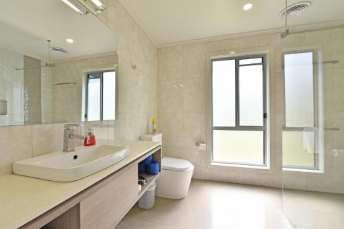 een witte badkamer met een wastafel en een toilet bij Ironbark Hill Villa 2 Aneis in Pokolbin