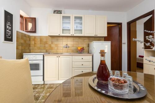 a kitchen with a table with a bottle on it at Apartments with parking space Kastel Stafilic, Kastela - 16086 in Kaštela