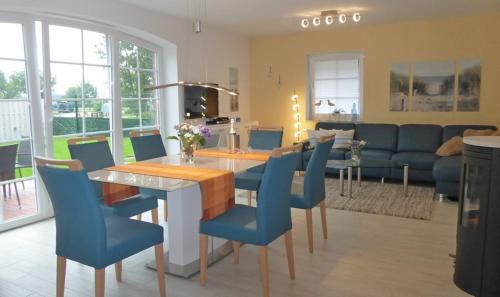 une salle à manger avec une table et des chaises bleues dans l'établissement An den Zwillingsmühlen, à Greetsiel