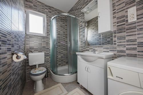 y baño con aseo, ducha y lavamanos. en Apartments with a parking space Kastel Stari, Kastela - 16087, en Kaštela
