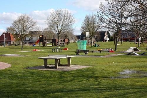 a park with several picnic tables and a playground at Hannes Koje in Greetsiel