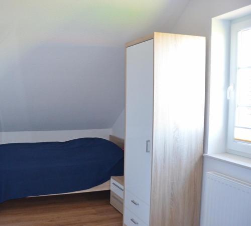 a bedroom with a blue bed and a cabinet at Aloha in Greetsiel
