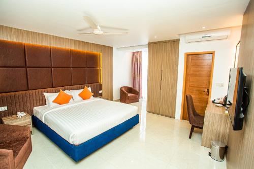 a hotel room with a bed and a television at Royal Raj Hotel in Rājshāhi