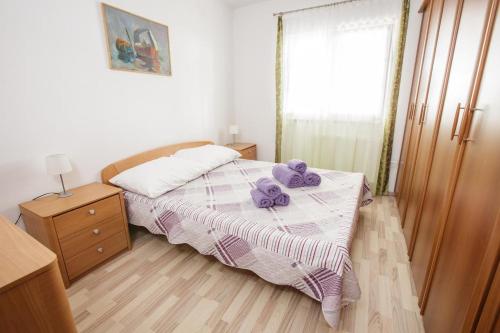 a bedroom with a bed with purple towels on it at Holiday house with a swimming pool Smrika, Kraljevica - 16050 in Šmrika