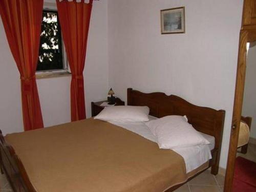 a bedroom with a bed with red curtains and a window at Apartments by the sea Brist, Makarska - 16098 in Podaca