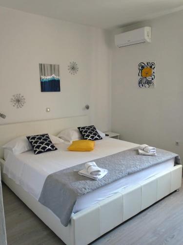 a white bedroom with a large white bed in a room at Apartments by the sea Pag - 16100 in Pag