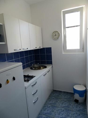 a kitchen with white cabinets and a sink and a window at Apartments by the sea Pag - 16100 in Pag