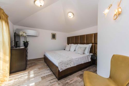 a bedroom with a bed and a chair at Seaside luxury villa with a swimming pool Cove Mihovilje, Pag - 16124 in Novalja