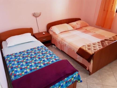 a bedroom with two beds and a lamp in it at Apartments by the sea Prigradica, Korcula - 16125 in Blato