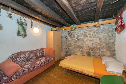 a living room with a couch and a stone wall at Holiday house with a parking space Starigrad, Paklenica - 16126 in Starigrad
