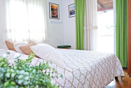 1 dormitorio con 1 cama con cortinas verdes en Seaside holiday house Sali, Dugi otok - 16128, en Sali