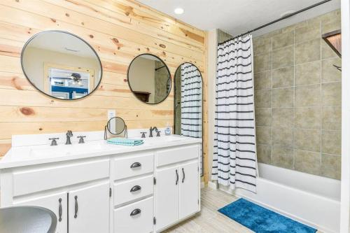 La salle de bains est pourvue d'un lavabo blanc, d'une baignoire et d'un miroir. dans l'établissement *New Listing* Turquoise Breeze *Pool Table* Sleeps 11, à Crystal Beach