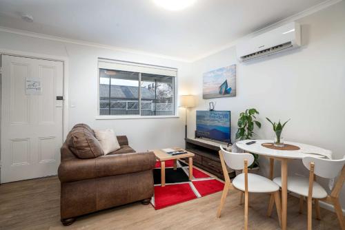 een woonkamer met een bank en een tafel bij One-Bedroom Apartment on Summer in Orange