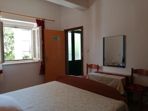1 dormitorio con 2 camas, espejo y ventana en Apartments by the sea Podgora, Makarska - 16159 en Podgora