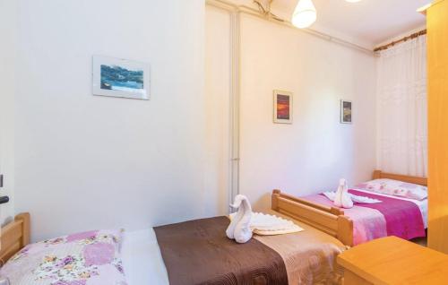 two beds in a small room with swans on them at Apartments with a parking space Cres - 16178 in Cres