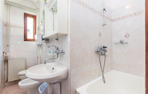 a white bathroom with a sink and a toilet at Apartments with a parking space Cres - 16178 in Cres