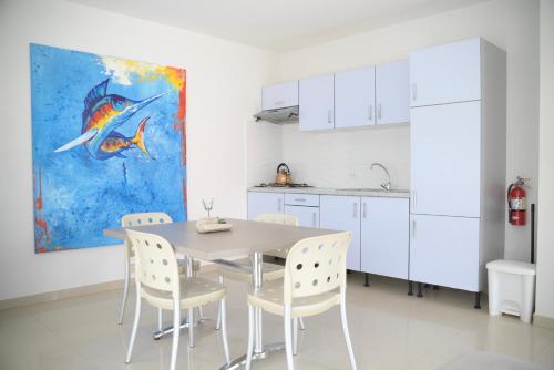 una cocina con mesa, sillas y una pintura en Beach Homes Aruba, en Noord