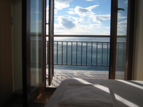 een slaapkamer met uitzicht op de oceaan vanaf een balkon bij Apartments with a parking space Senj - 15376 in Senj